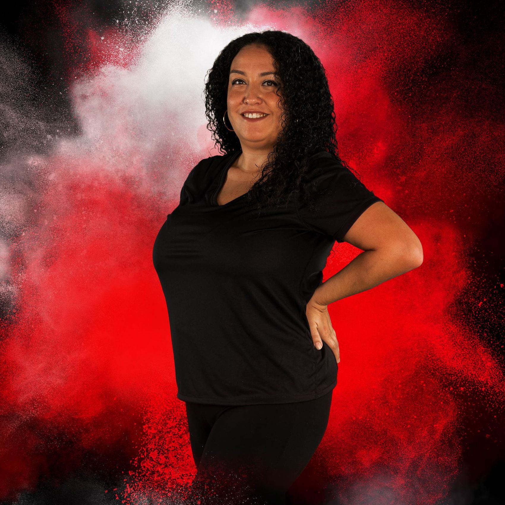 A woman in a black shirt is standing in front of a red background.