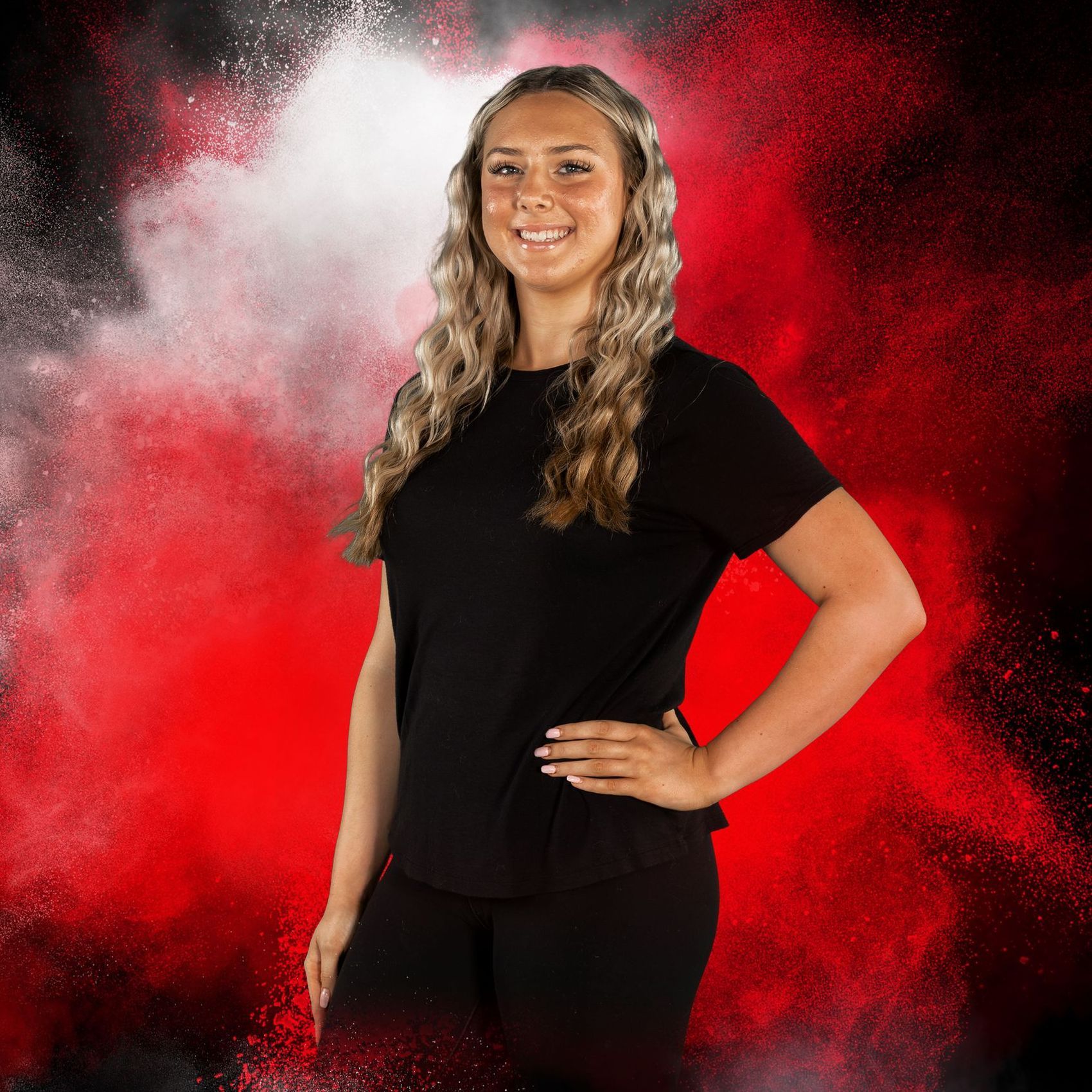 A woman in a black shirt is standing in front of a red background.
