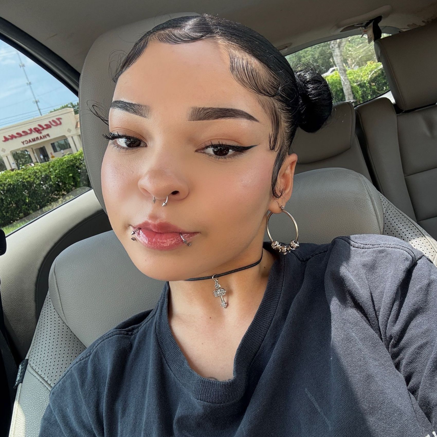 A woman is taking a selfie in the back seat of a car