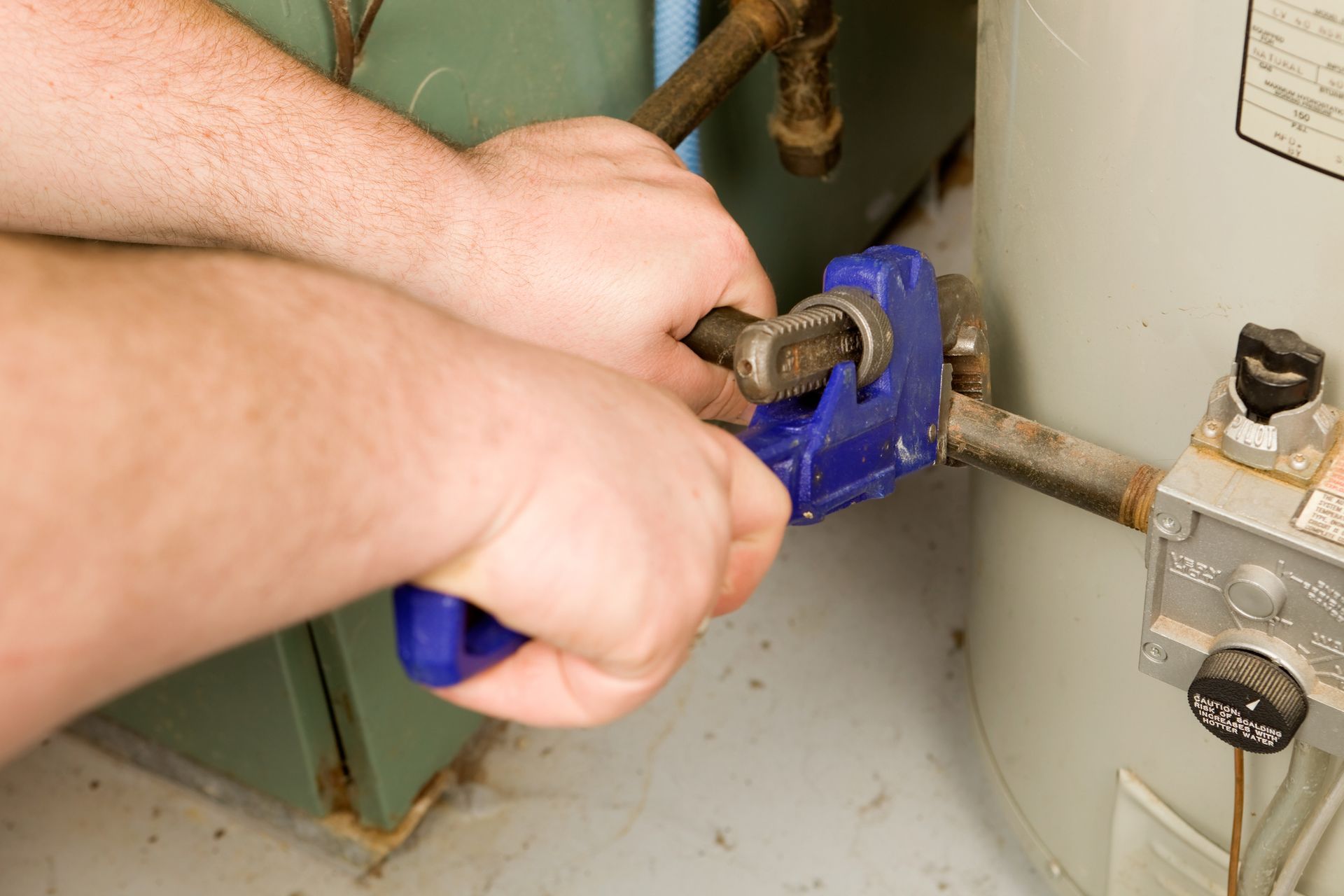 A close up of a water heater with copper pipes attached to it. A close up of a water heater with copper pipes attached to it.
