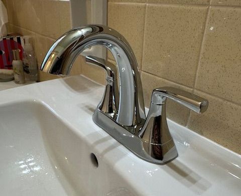 A bathroom sink with a chrome faucet on it. A bathroom sink with a chrome faucet on it.