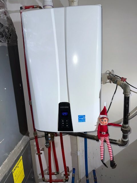 An elf on the shelf is sitting next to a water heater.