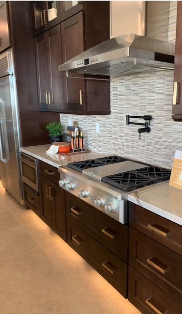 A kitchen with a stove top oven and a refrigerator.