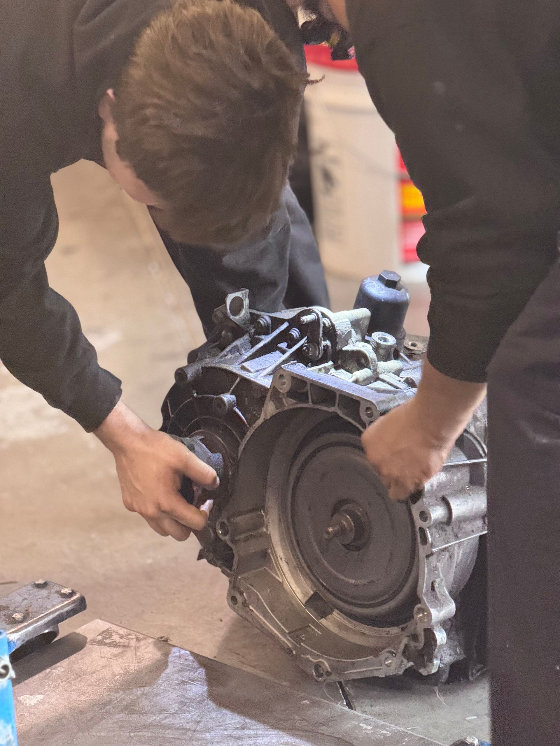 A man is working on a car engine in a garage
