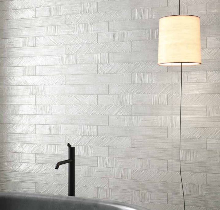 rivestimento bagno in ceramica bianco con piastrelle orizzontali e fregi