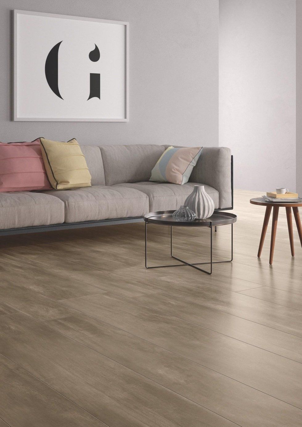 salotto con pavimento effetto legno in ceramica e divano grigio