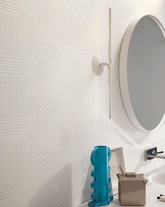 bagno con parete in ceramica intarsiata bianca