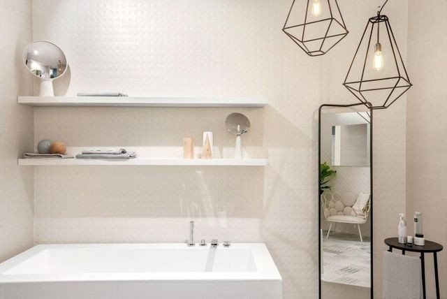 bagno con rivestimenti in ceramica intarsiata bianca