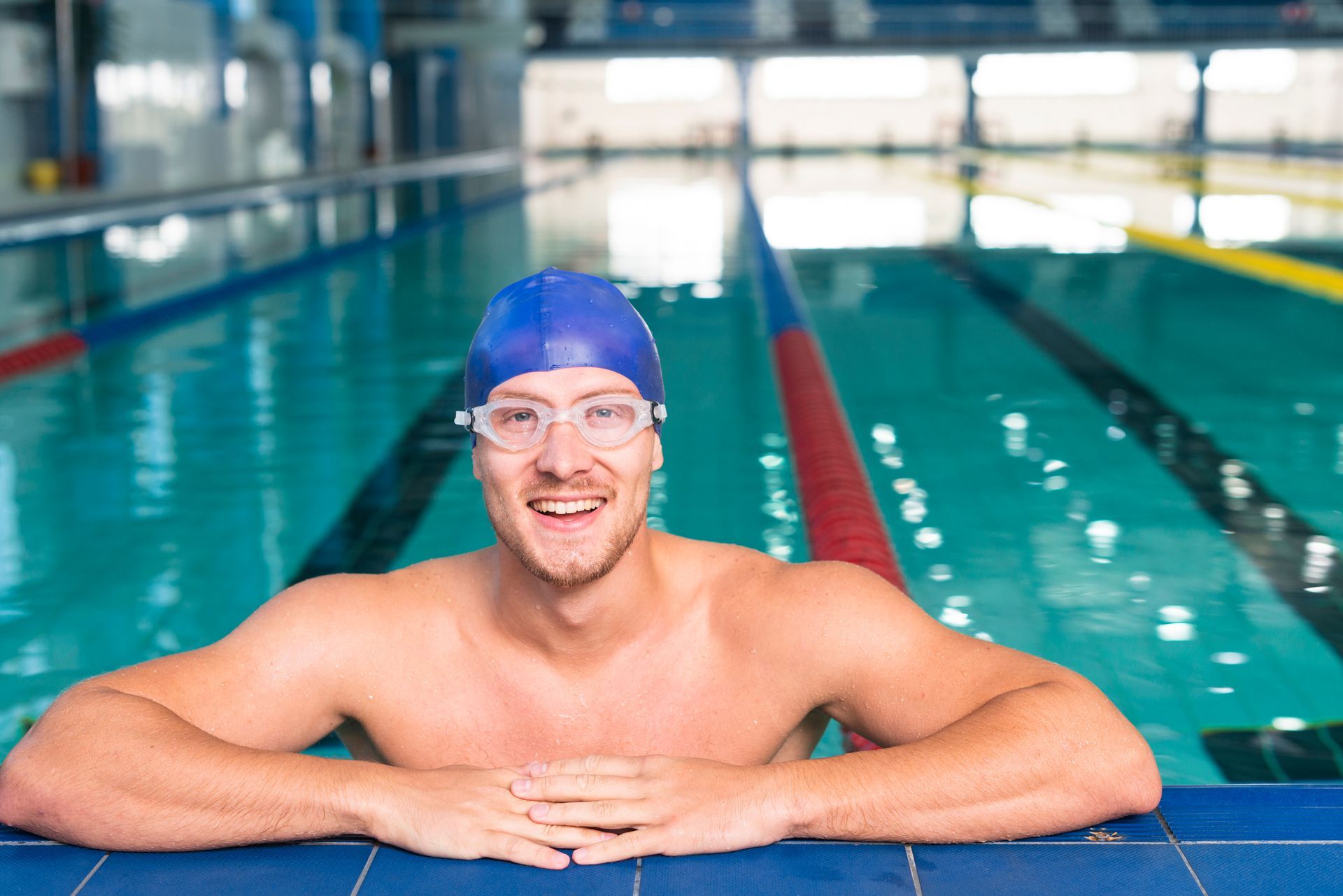 A man is leaning on the edge of a swimming pool.