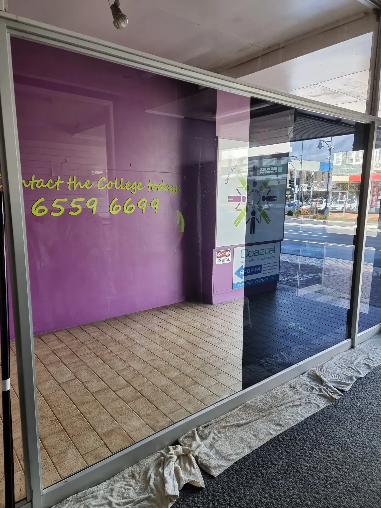 Empty Shop Interior With Purple Walls, Glass Front, and Phone Number — Awesome Window Tint In Wauchope, NSW