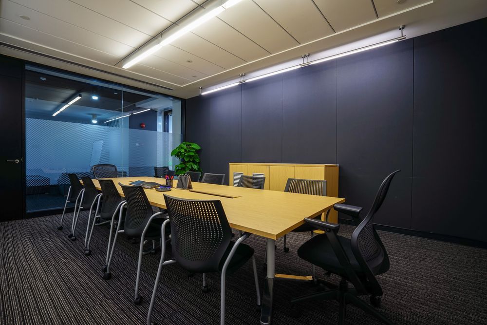 Modern Office Conference Room With a Long Table, Chairs, and Dark Walls — Awesome Window Tint In Wauchope, NSW