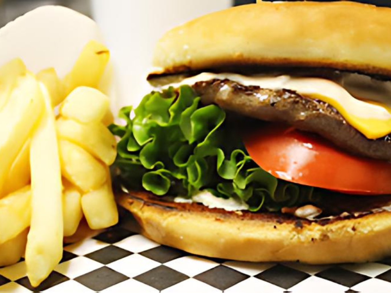 A hamburger and french fries on a checkered table cloth