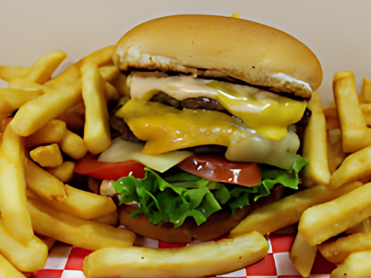 A hamburger is sitting on top of a pile of french fries.