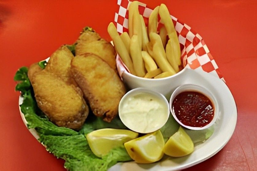 A plate of fish and french fries on a red table