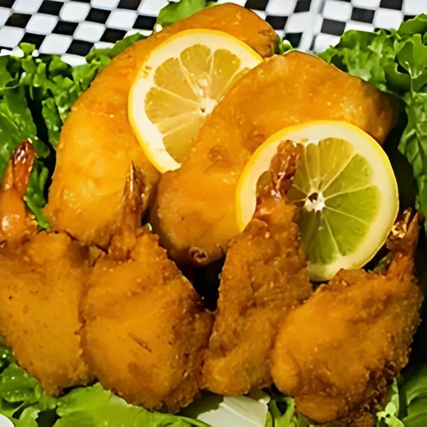 Fried shrimp with lemon slices and lettuce on a plate