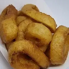 A close up of a bowl of onion rings on a table.