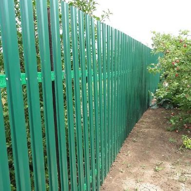 Green Corrugated Metal Fence in a Garden Setting — Fencer Steve In Hat Head, NSW