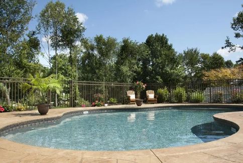 Swimming Pool With Lounge Chairs, Surrounded by Trees and a Fence — Fencer Steve In Crescent Head, NSW