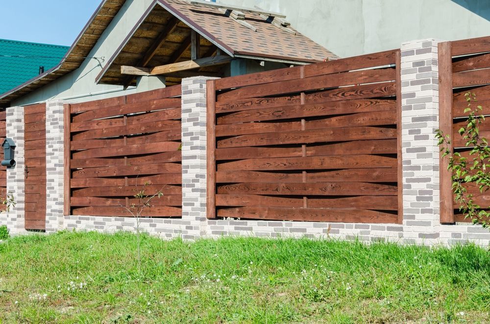 Brown Wooden Fence With Brick Columns, in Front of a House on a Grassy Lawn — Fencer Steve In South West Rocks, NSW