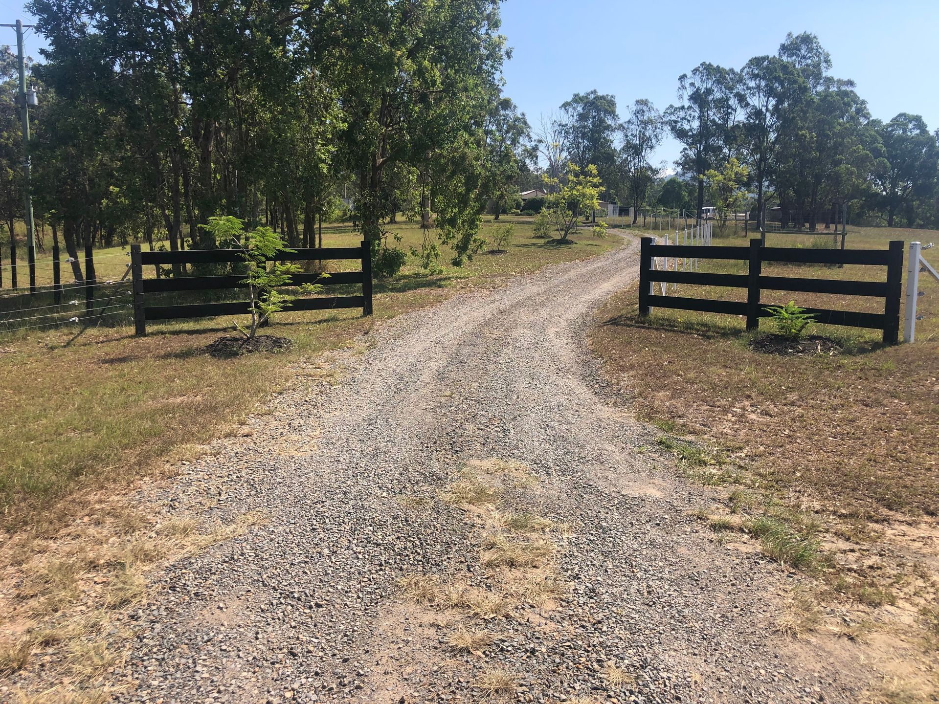 Gravel Driveway With Black Fences, Leading Into a Rural Property Lined — Fencer Steve In Hat Head, NSW