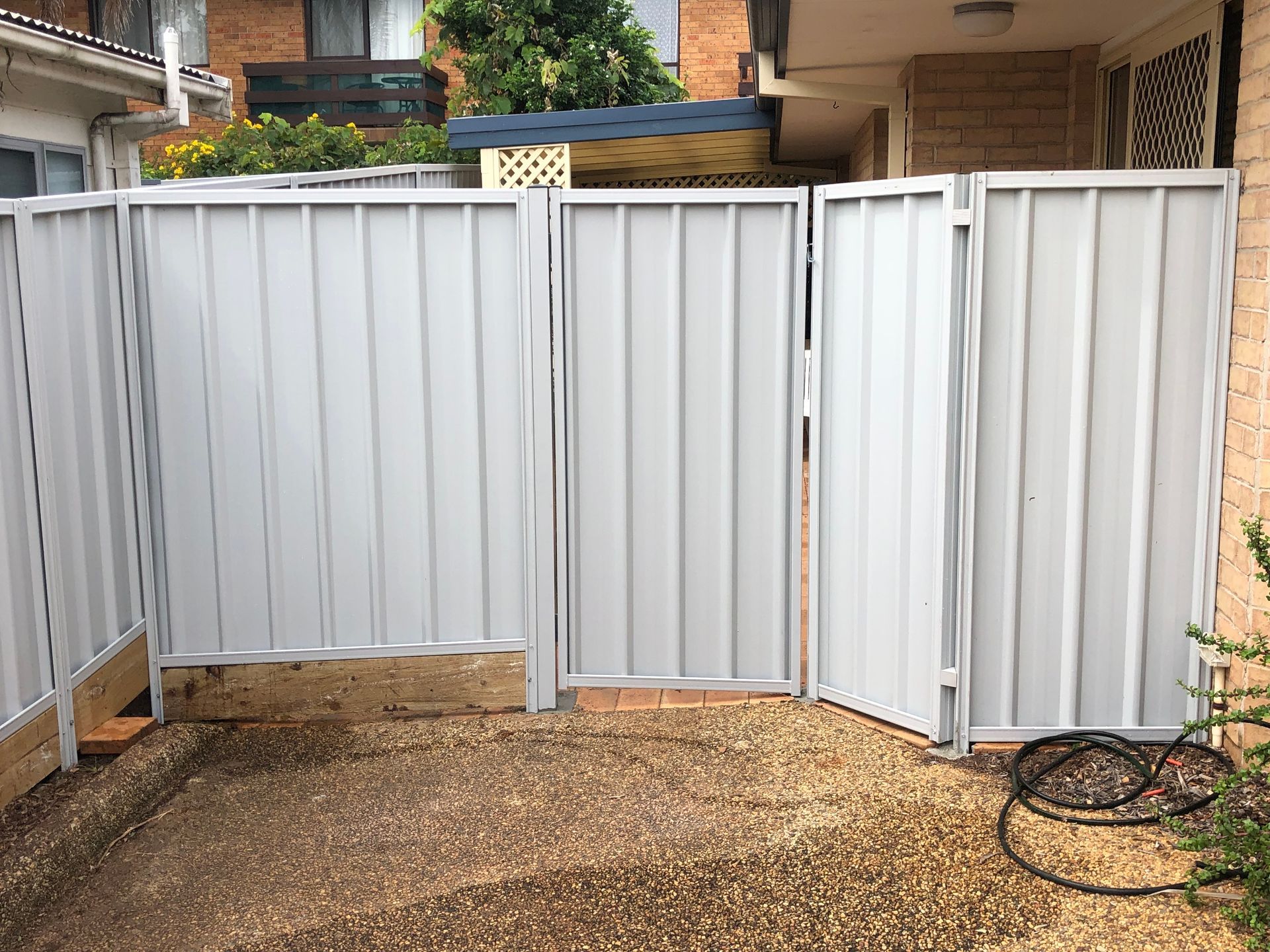 Grey Metal Gate, Composed of Three Vertical Panels, Opens to a Gravel Patio — Fencer Steve In Temagog, NSW