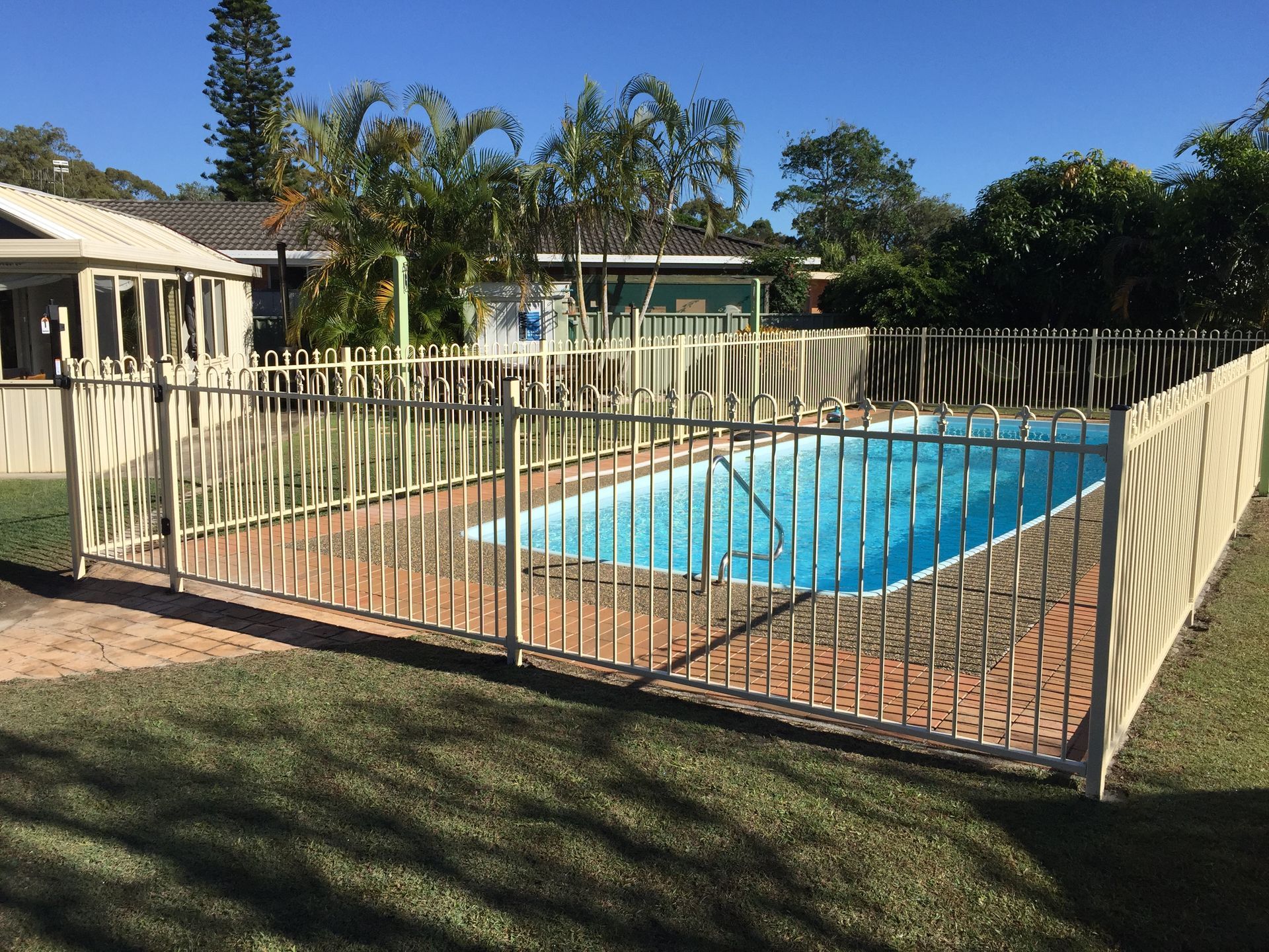 Pool Fenced in, Surrounded by Lawn and Trees, on a Sunny Day — Fencer Steve In Kempsey, NSW