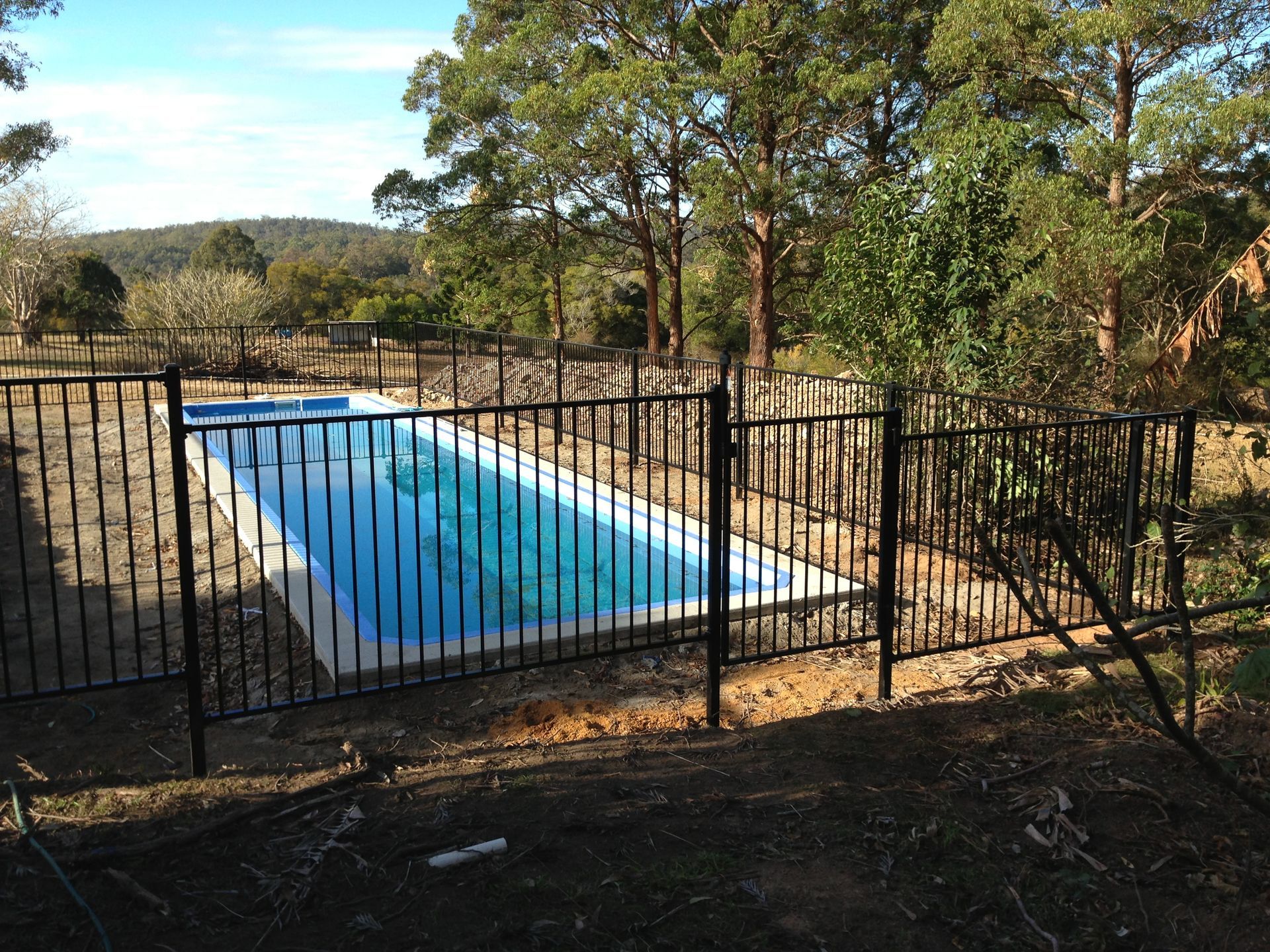 Black fenced rectangular swimming pool in a rural backyard — Fencer Steve In Temagog, NSW
