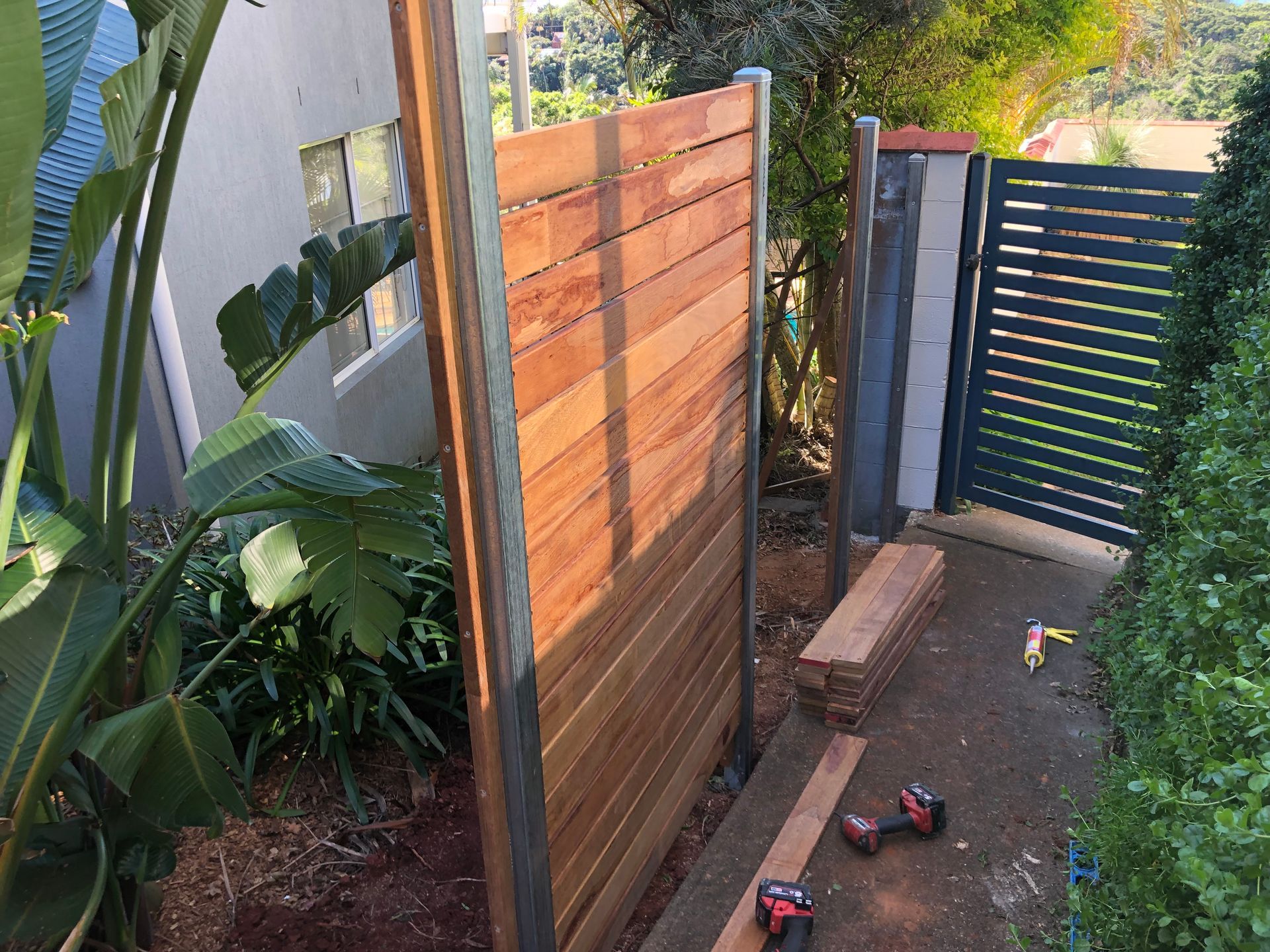 Wooden Fence With Horizontal Planks, Next to a Gate and Plants — Fencer Steve In Kempsey, NSW