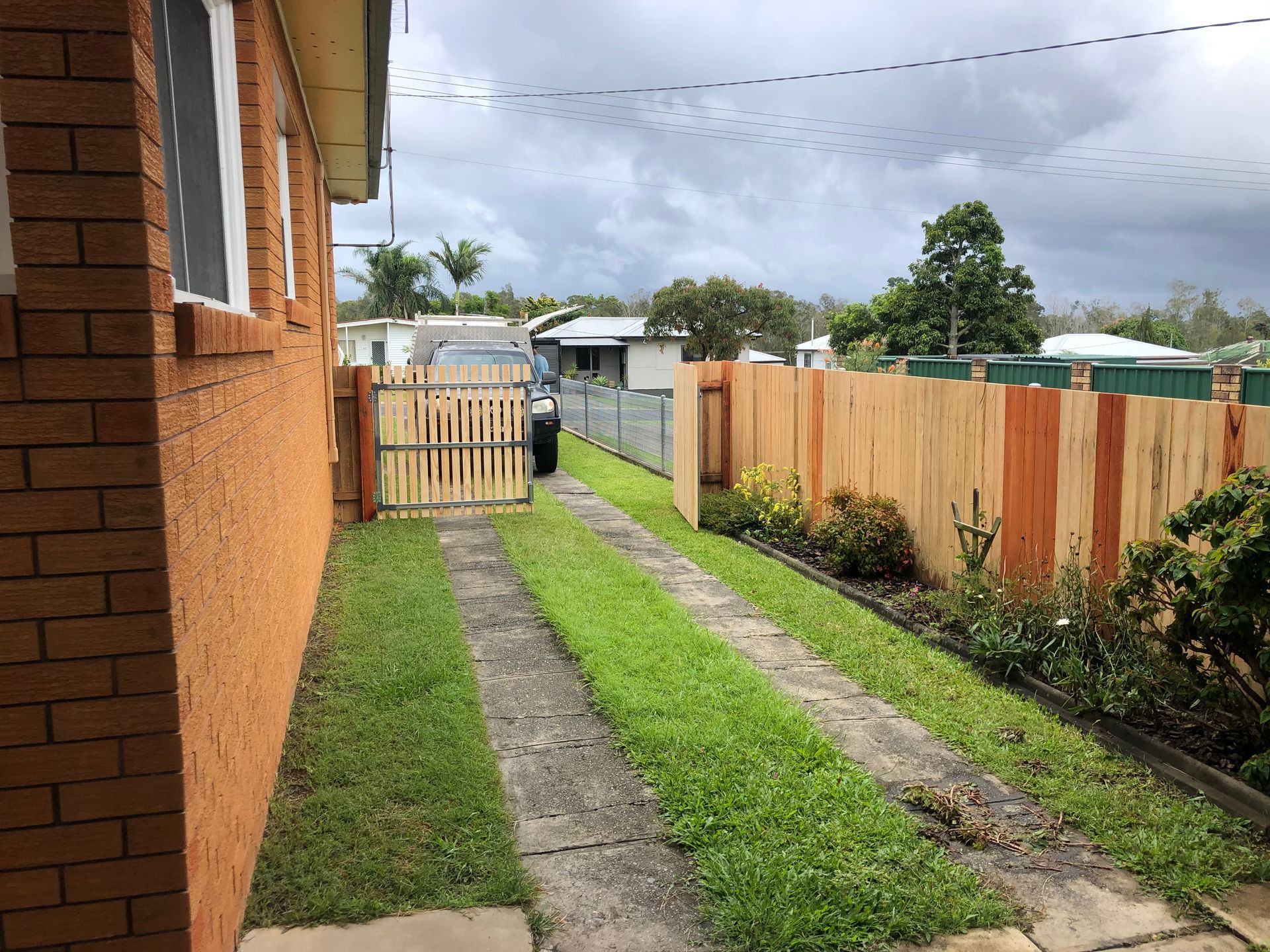 Driveway Between Brick Building and Wooden Fence — Fencer Steve In Laurieton, NSW