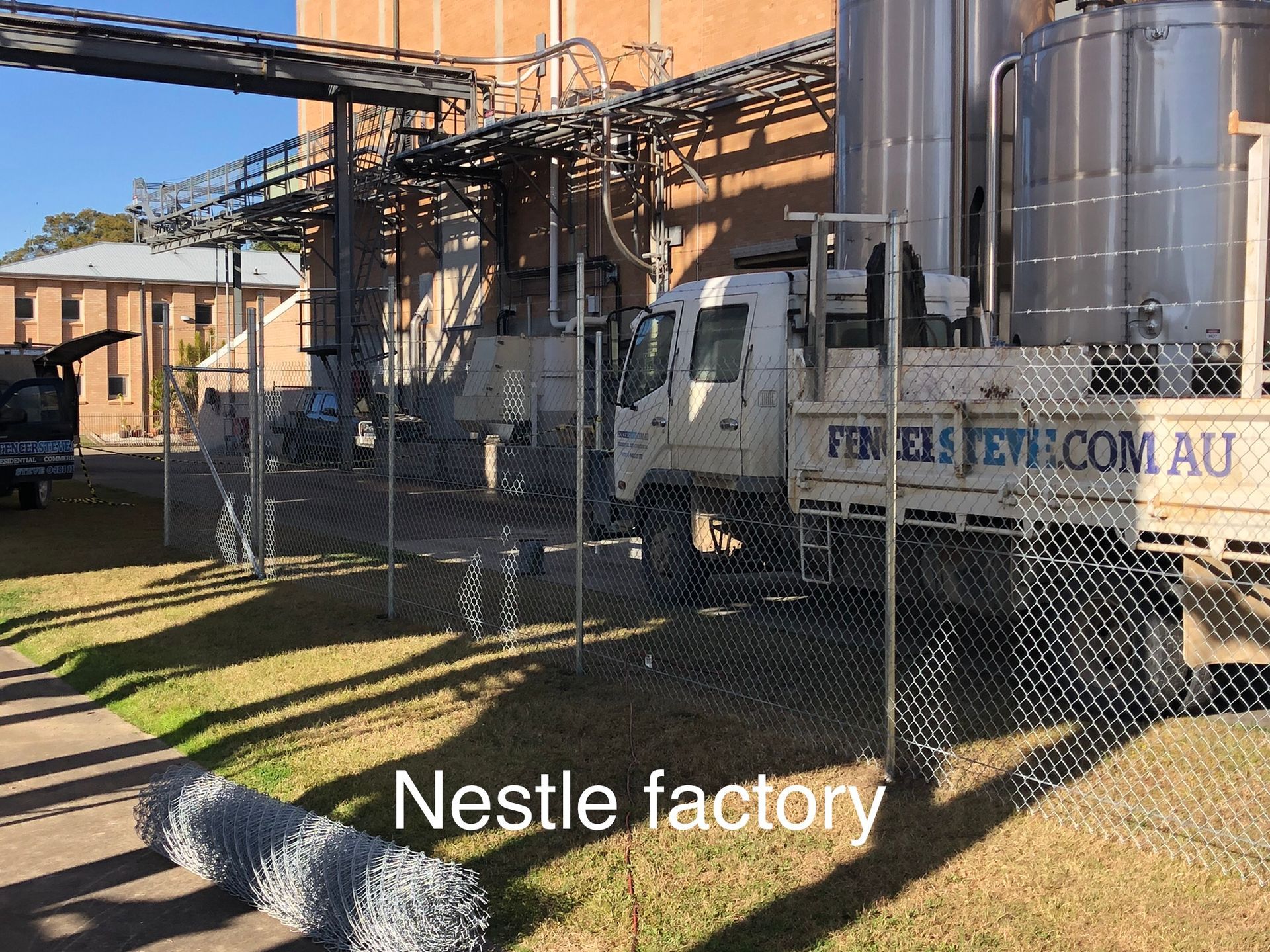 A truck and chain link fence at a Nestlé factory — Fencer Steve In Temagog, NSW