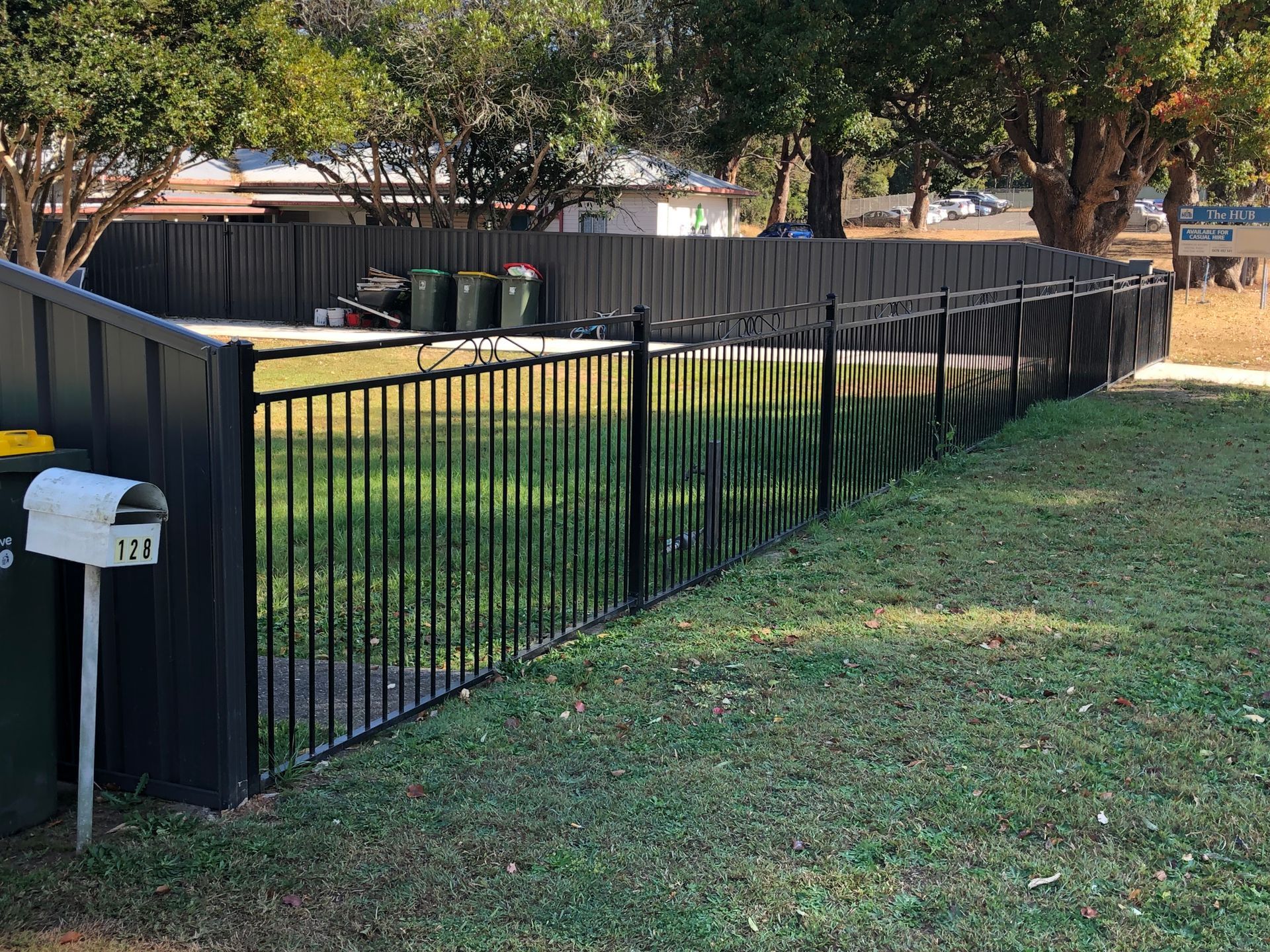 Black metal fence around a yard with grass and trees — Fencer Steve In Temagog, NSW