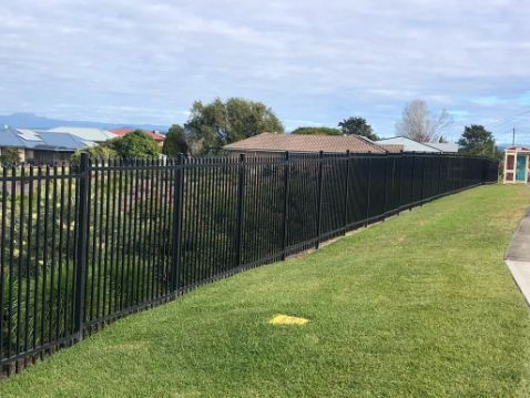 Black Metal Fence on a Grassy Hill — Fencer Steve In Laurieton, NSW