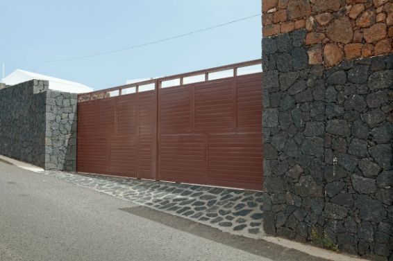 Brown Metal Gate Between Stone Walls on a Paved Road — Fencer Steve In Hat Head, NSW