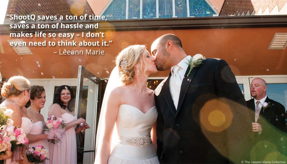 A bride and groom kissing in front of their wedding party