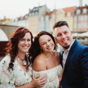 A man and two women are posing for a picture together.