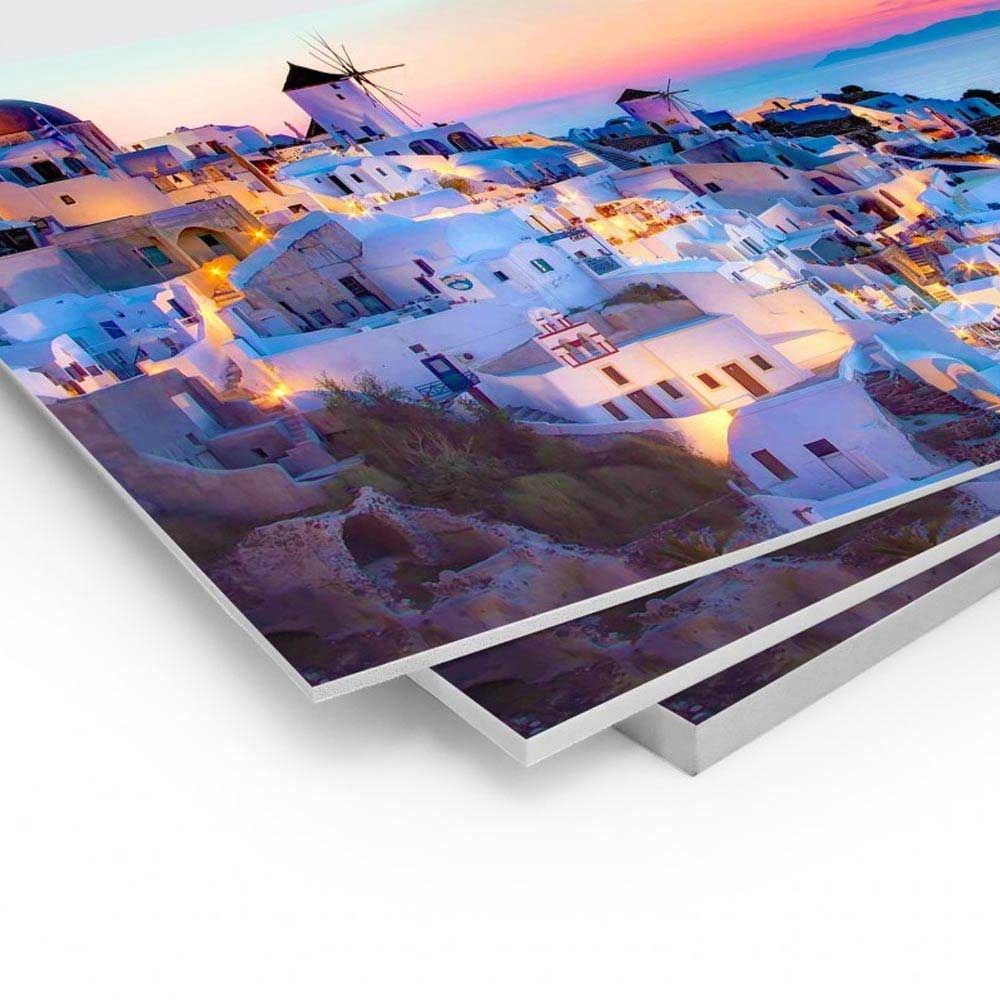 Stampe impilate che mostrano una vista panoramica al tramonto di edifici bianchi 