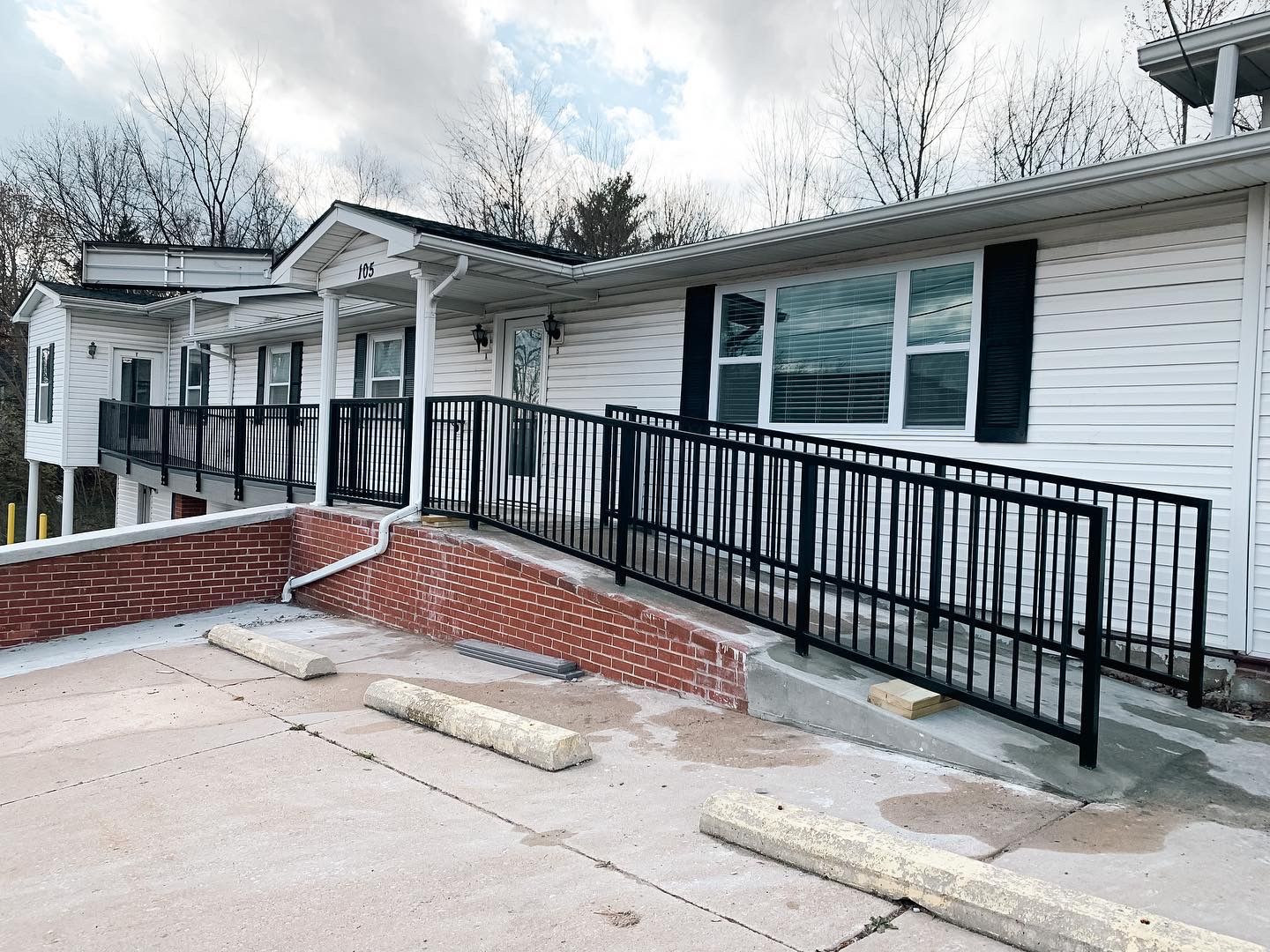 A Home Ramp With Sturdy Black Railings Installed By Merit Welding in Mid-MO.