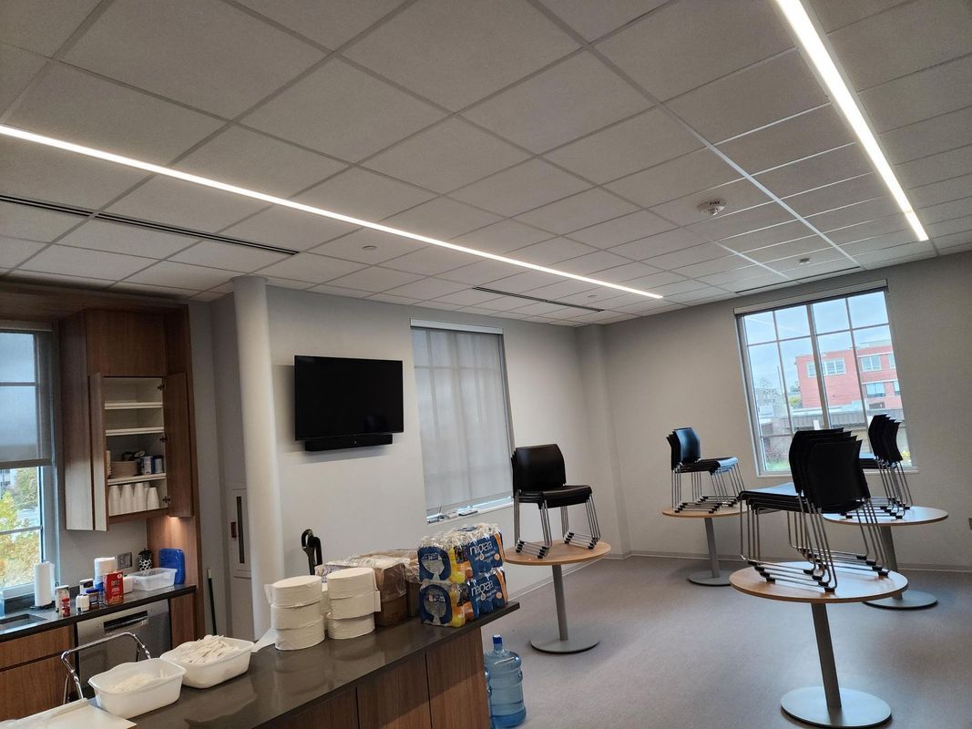 A well-lit room with a bar, chairs, and tables, likely a break room or waiting area.