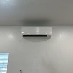 Two outdoor air conditioning units on a brick patio, near a house.
