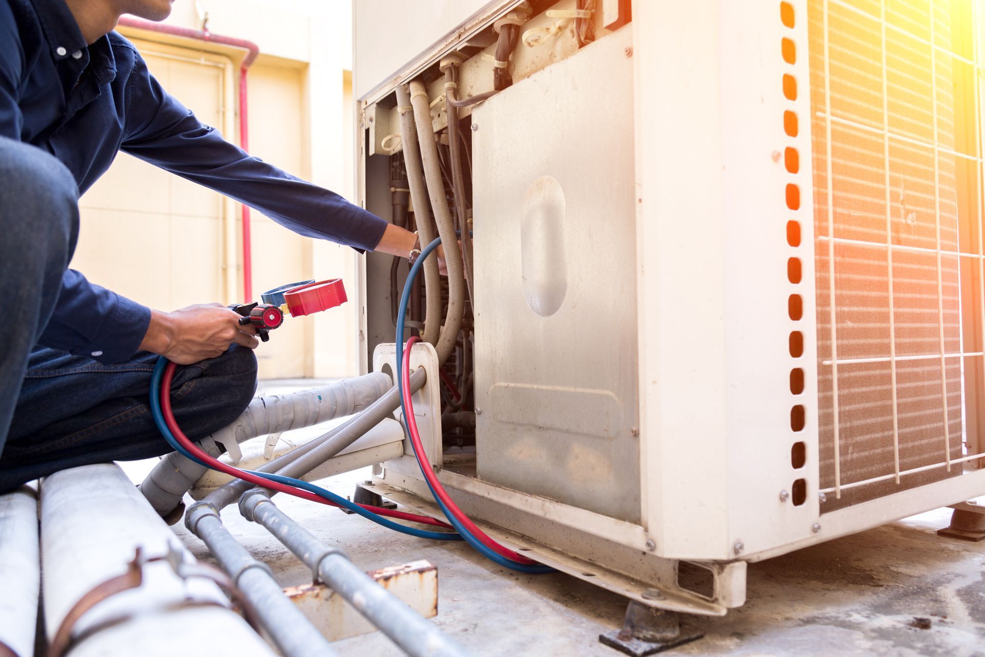 HVAC technician inspecting an outdoor unit with a multimeter.