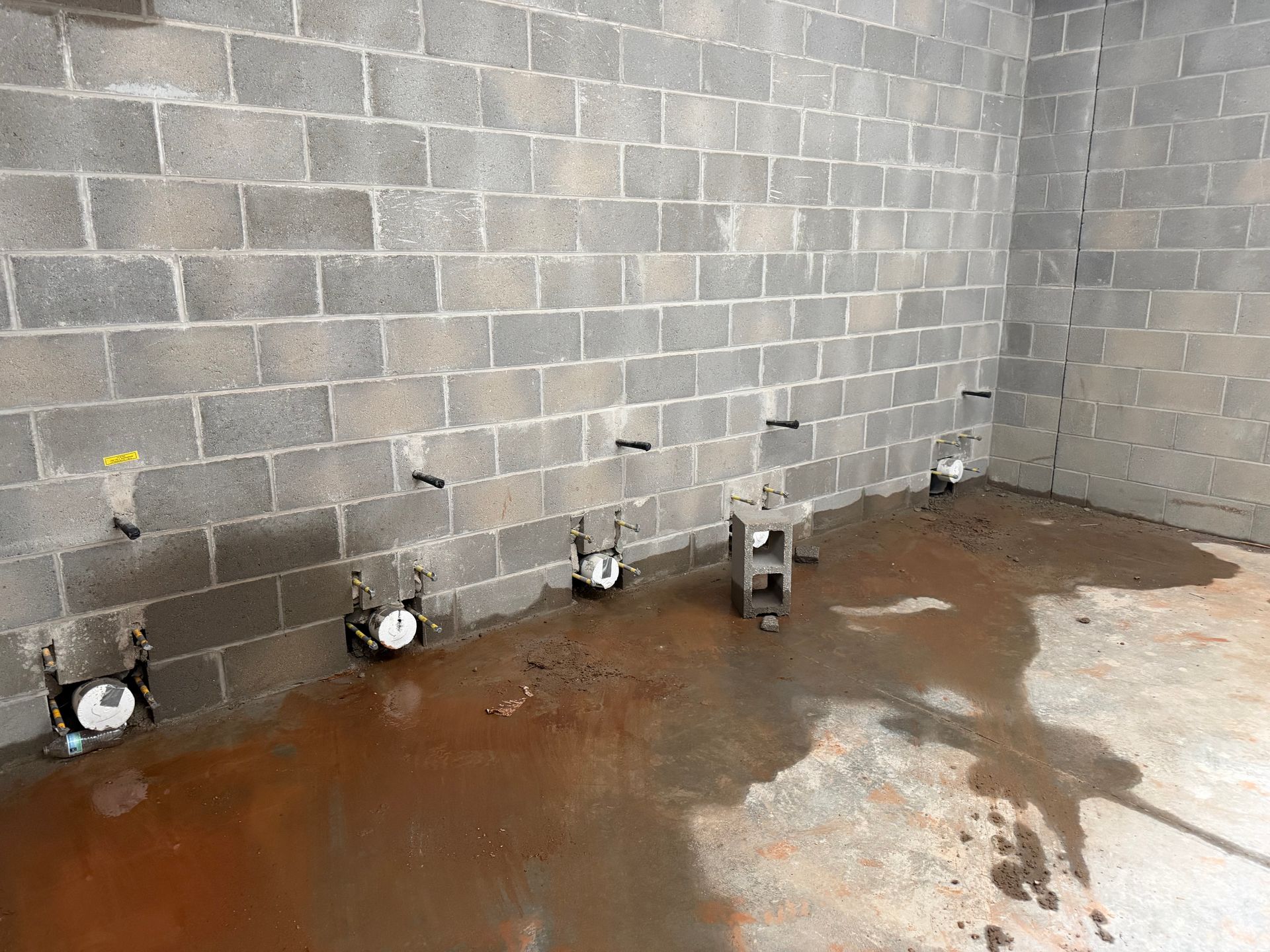 Plumber holding tools and hoses near a kitchen sink.