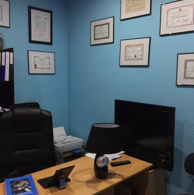 Una habitación con paredes azules y un escritorio con una lámpara encima.