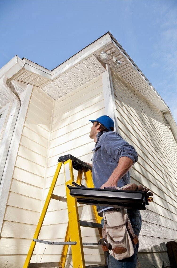 Langley Handyman on ladder at exterior of house