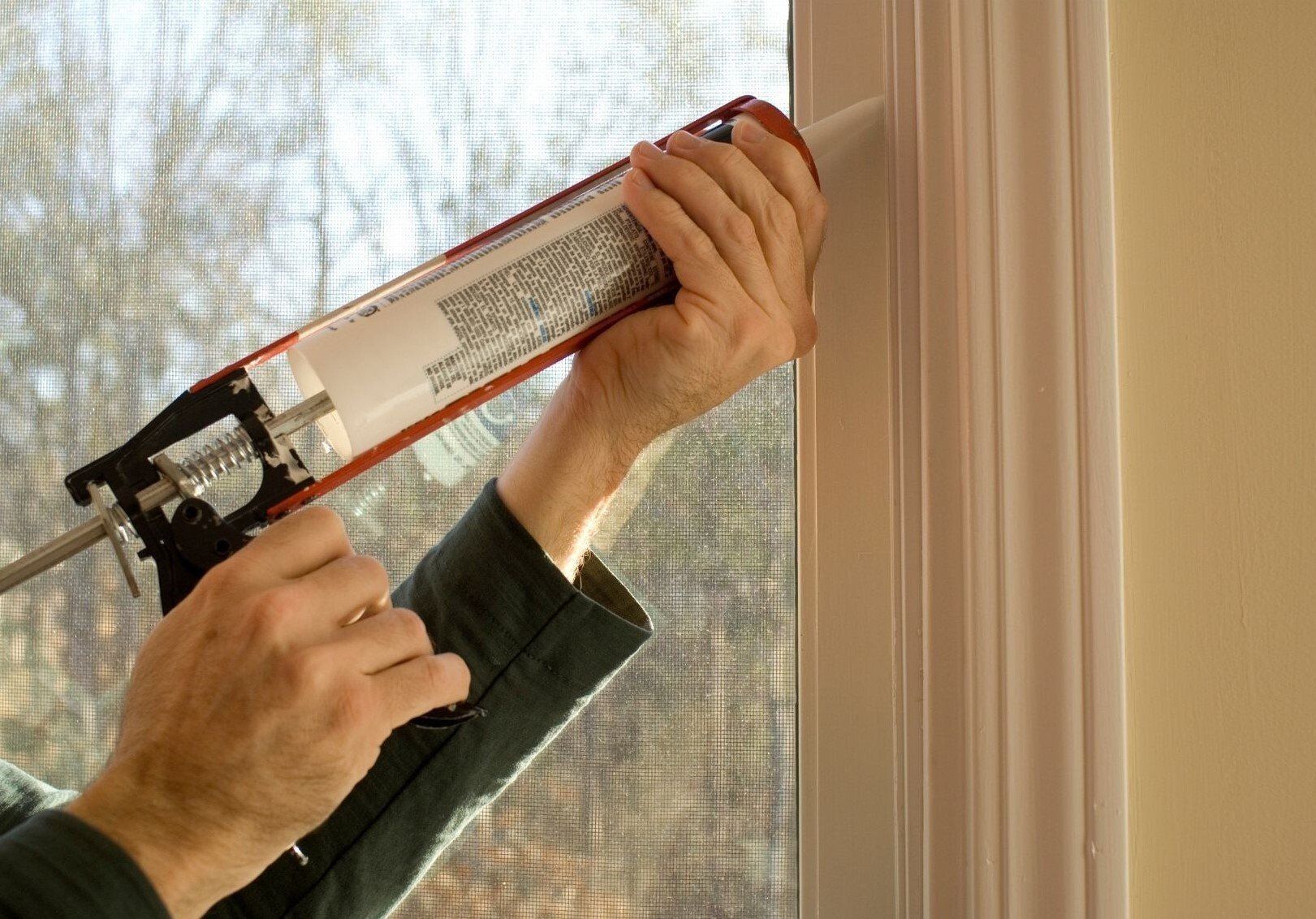 Caulking being installed at interior window frame