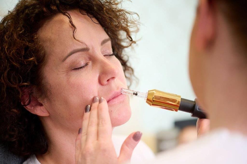 Eine Frau bekommt eine Botox-Injektion in die Lippen.