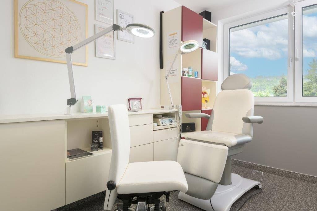 In einem Raum neben einem Fenster steht ein weißer Stuhl.