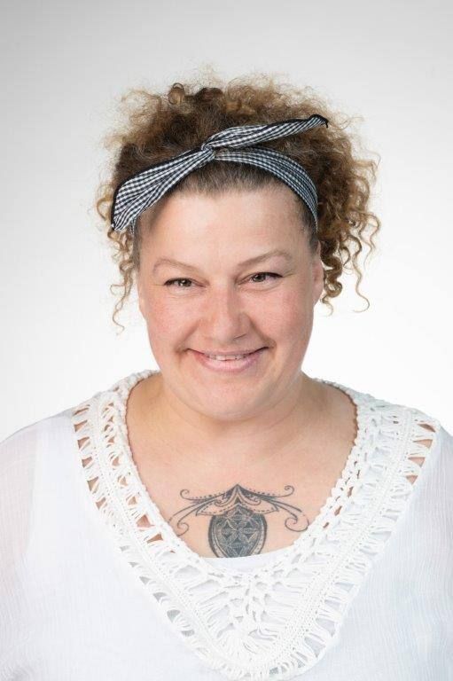 Eine Frau mit Brille und Mickey-Mouse-Shirt lächelt in die Kamera.