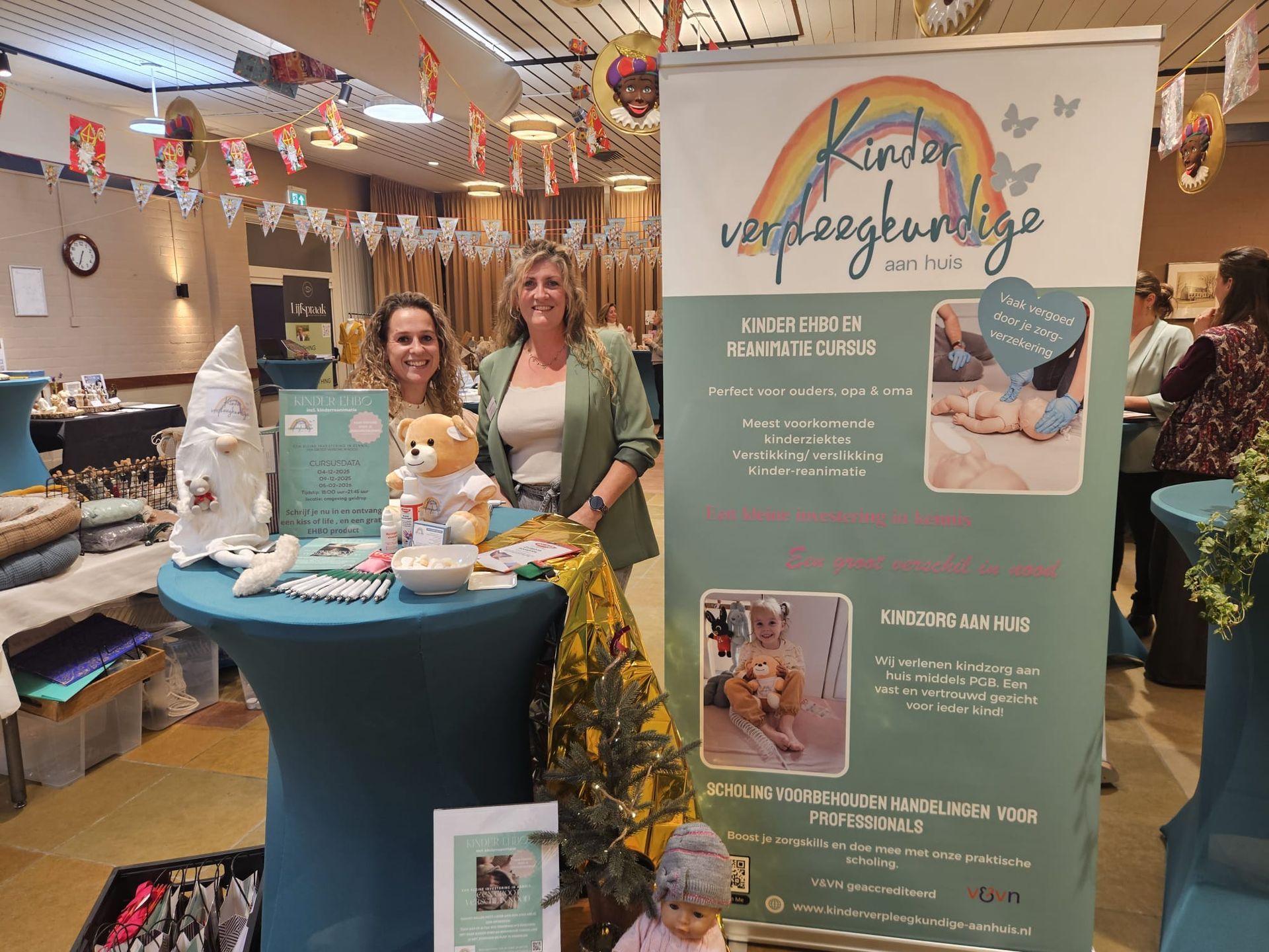 Twee vrouwen bij een kraampje met een spandoek