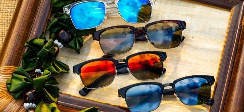 A group of sunglasses are sitting on top of a wooden frame.