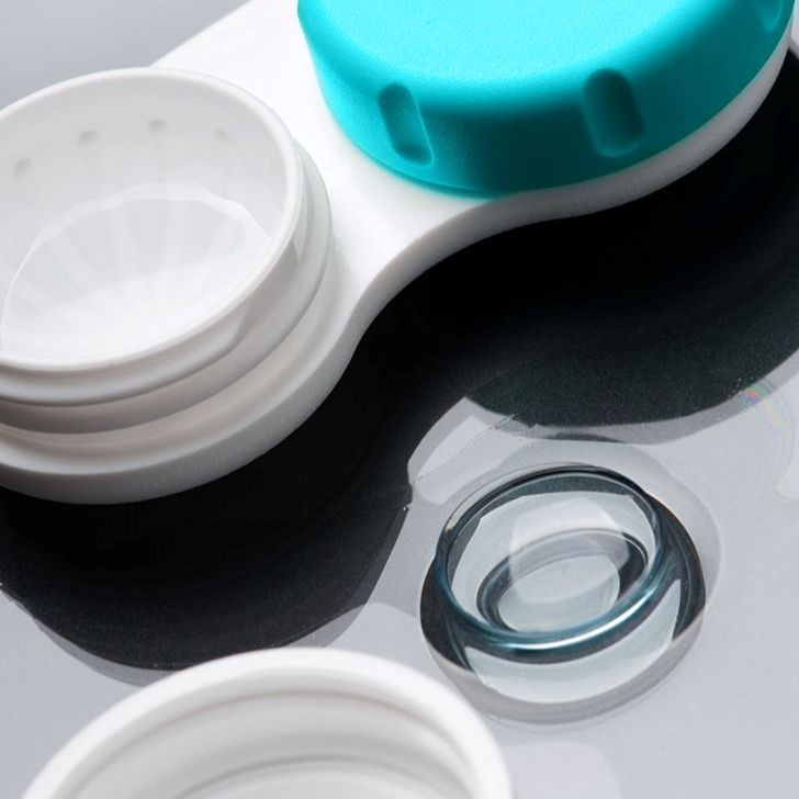 A close up of a contact lens case with a blue lid